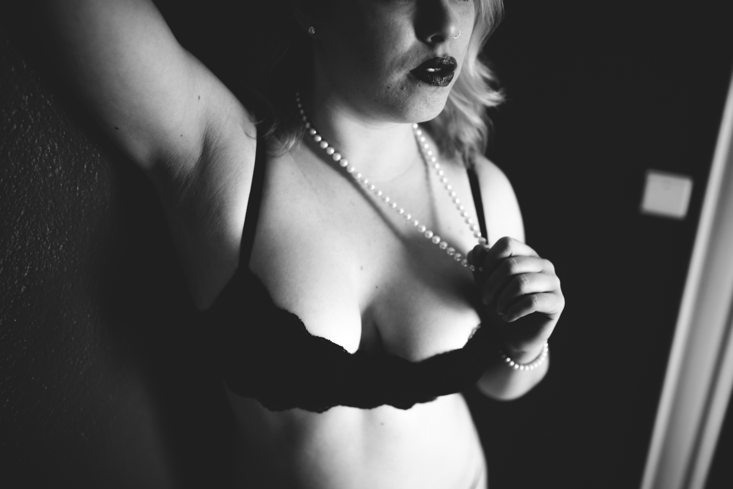 black and white boudoir photo of a woman holding her pearls. Boudoir photography by st paul photographer The Hawk & Sparrow